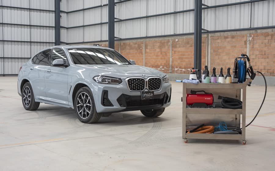 Auto recién lavado junto al carrito de productos de On Site
