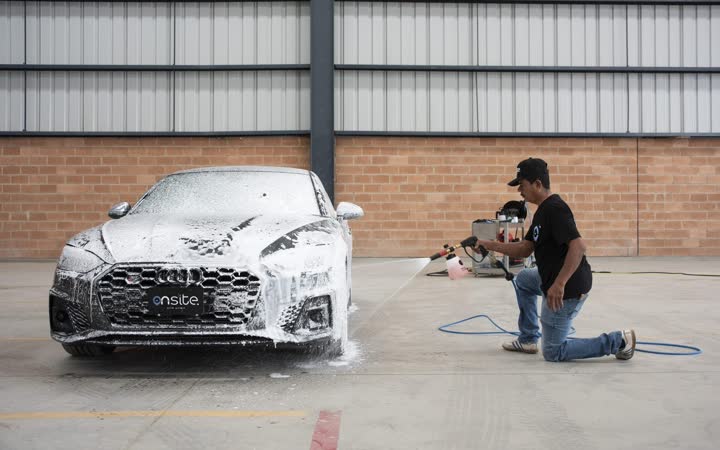 Lavador de On Site junto a un auto cubierto de espuma
